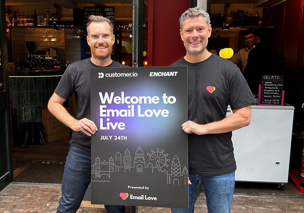 Andy King and Matt Hayes holding a Welcome to Email Love Live sign outside the event venue in London